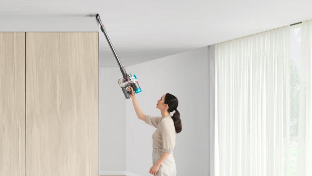 Woman cleaning up high with Dyson V8 vacuum