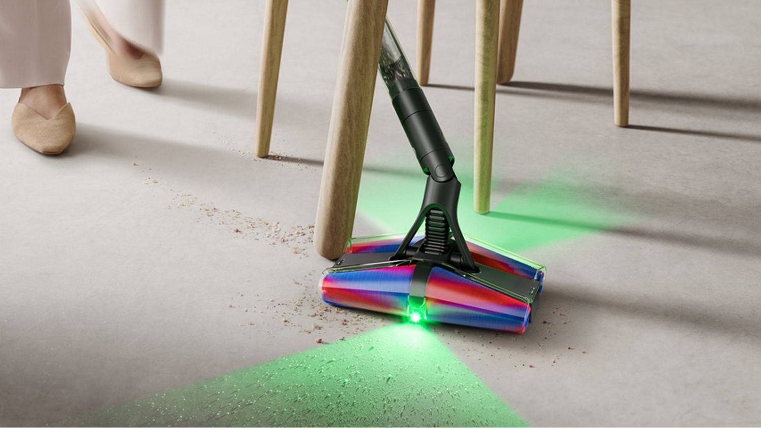 The Dyson PencilVac manoeuvring around a table and chair cleaning debris.