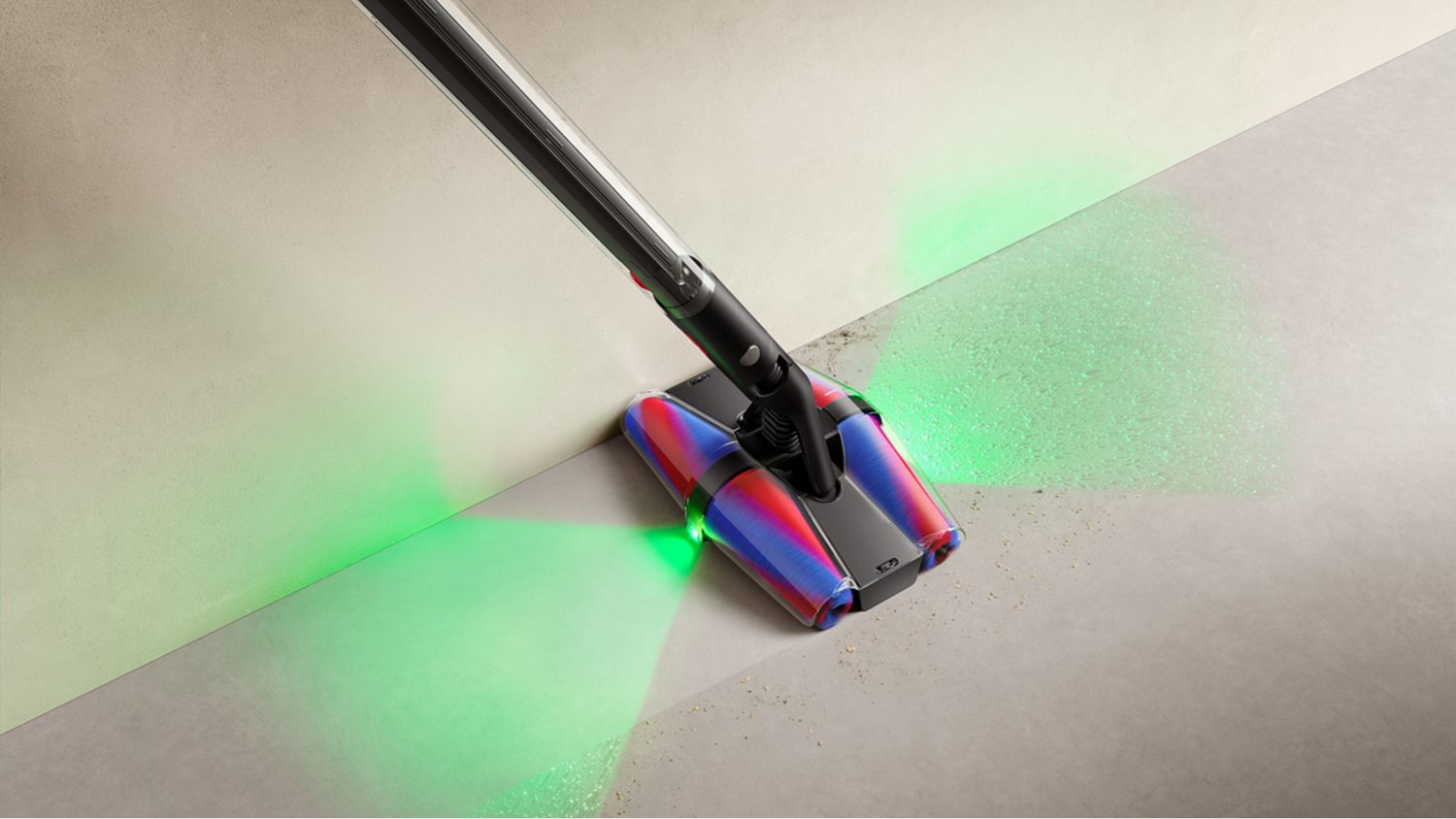 The Dyson PencilVac showcasing the front and rear laser picking up dust on a hard floor.