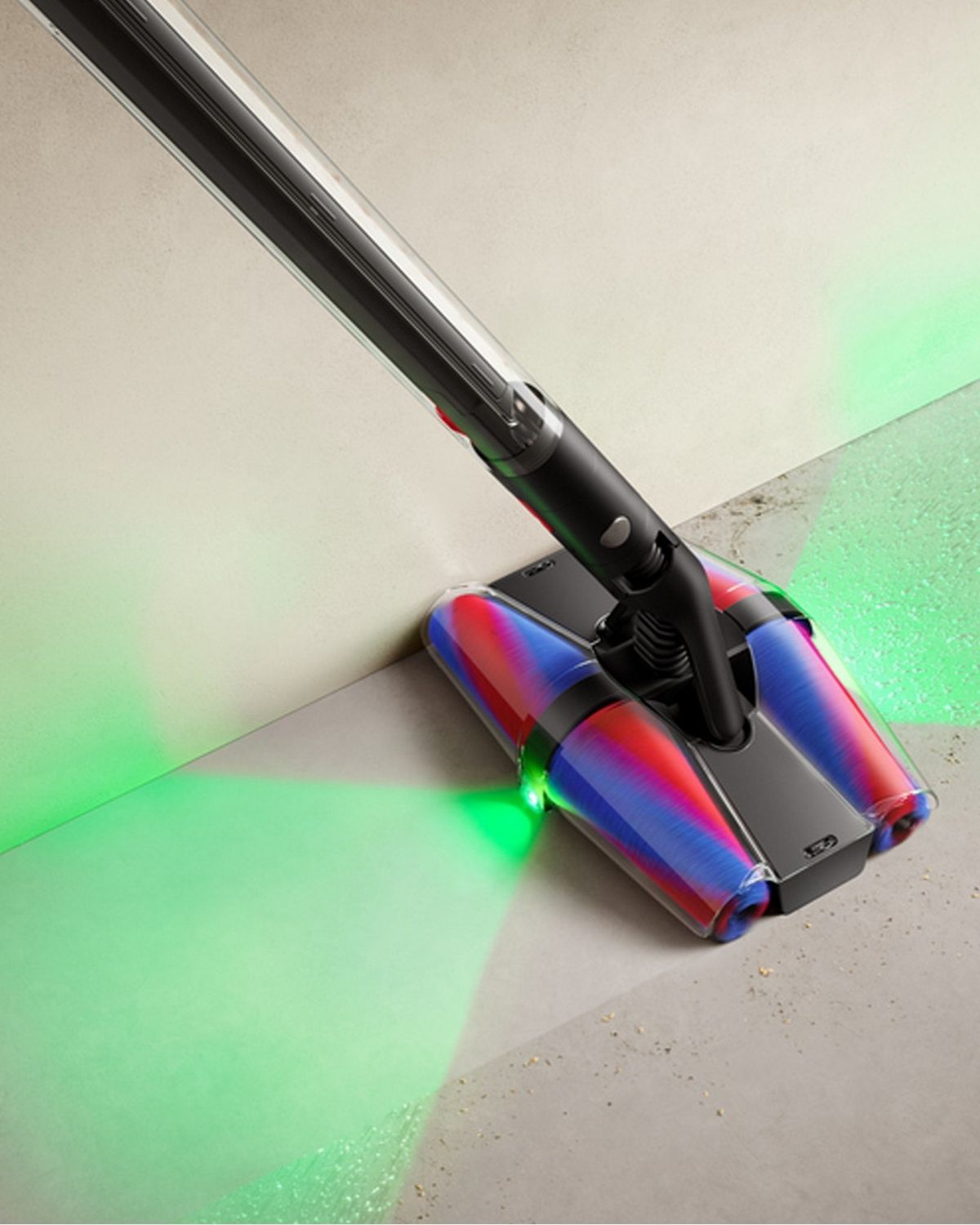 The Dyson PencilVac showcasing the front and rear laser picking up dust on a hard floor.