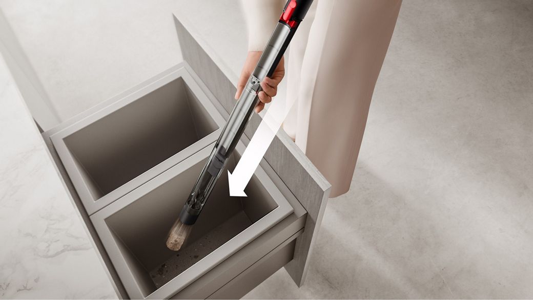 Pembersih Dyson PencilVac Fluffycones dikosongkan ke dalam tempat sampah.