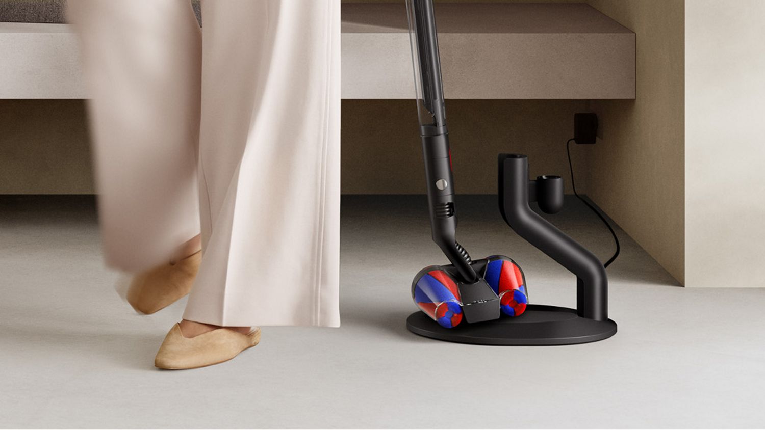 A Dyson PencilVac vacuum being removed from its docking station.