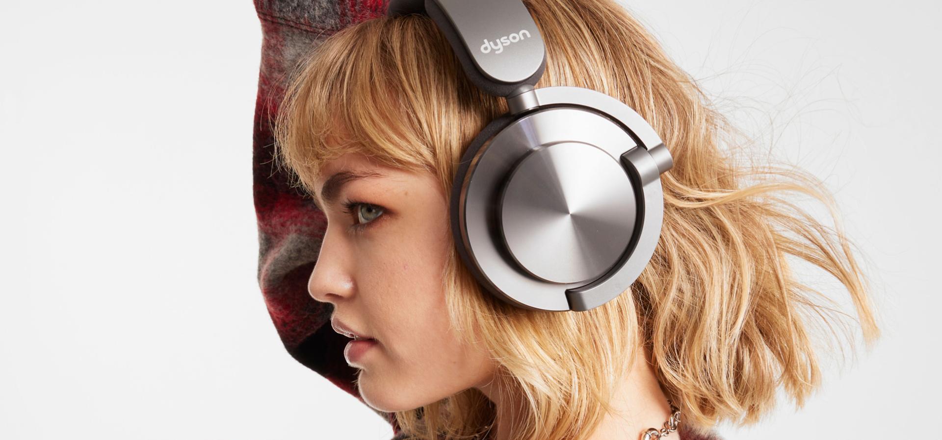 Model listens to music on their Dyson OnTrac headphones.