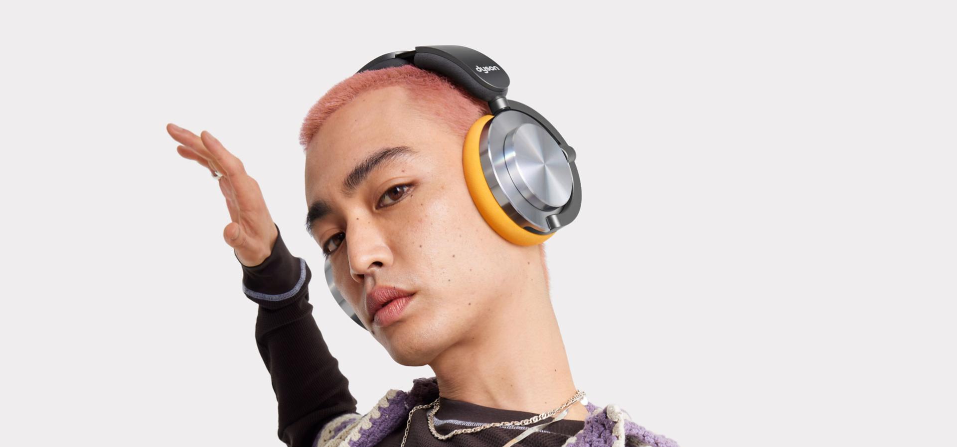 Model listens to music on their Dyson OnTrac headphones.