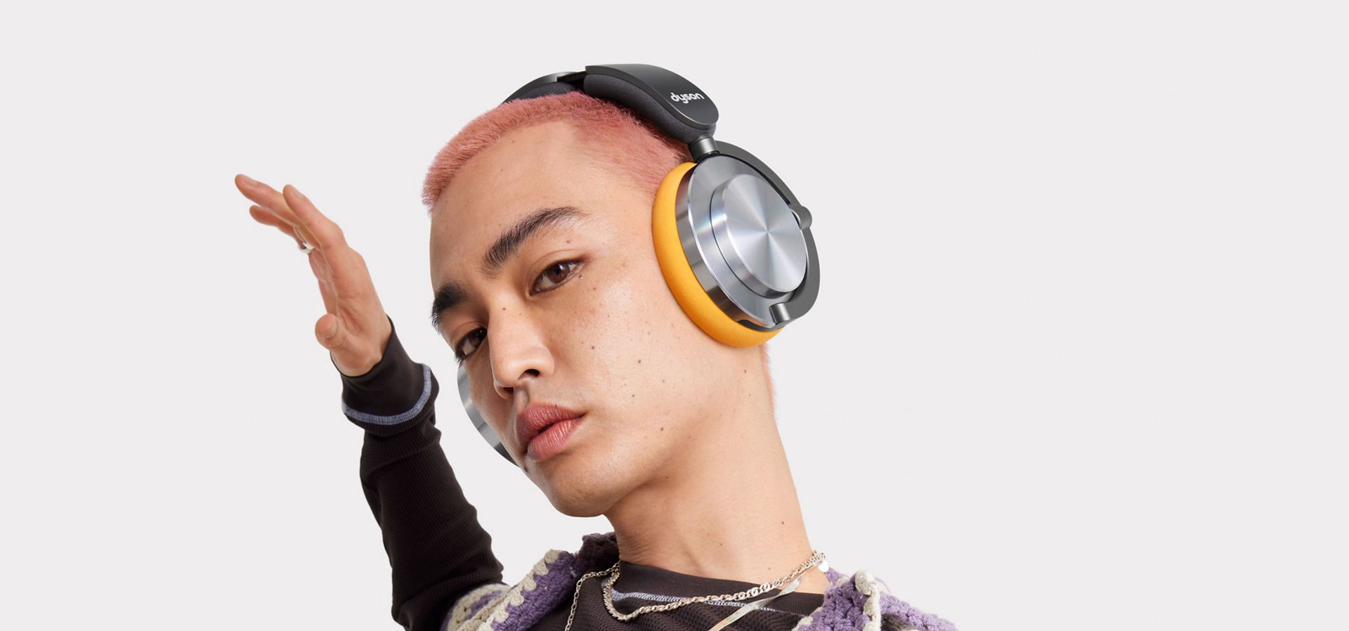 Model listens to music on their Dyson OnTrac headphones.