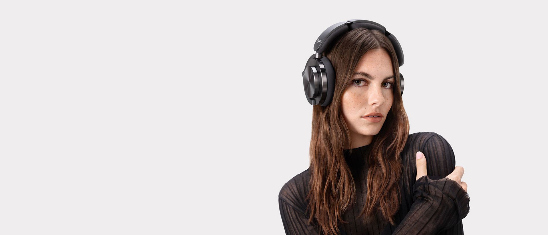 A model wearing Dyson OnTrac headphones with CNC Black Nickel Outer caps.