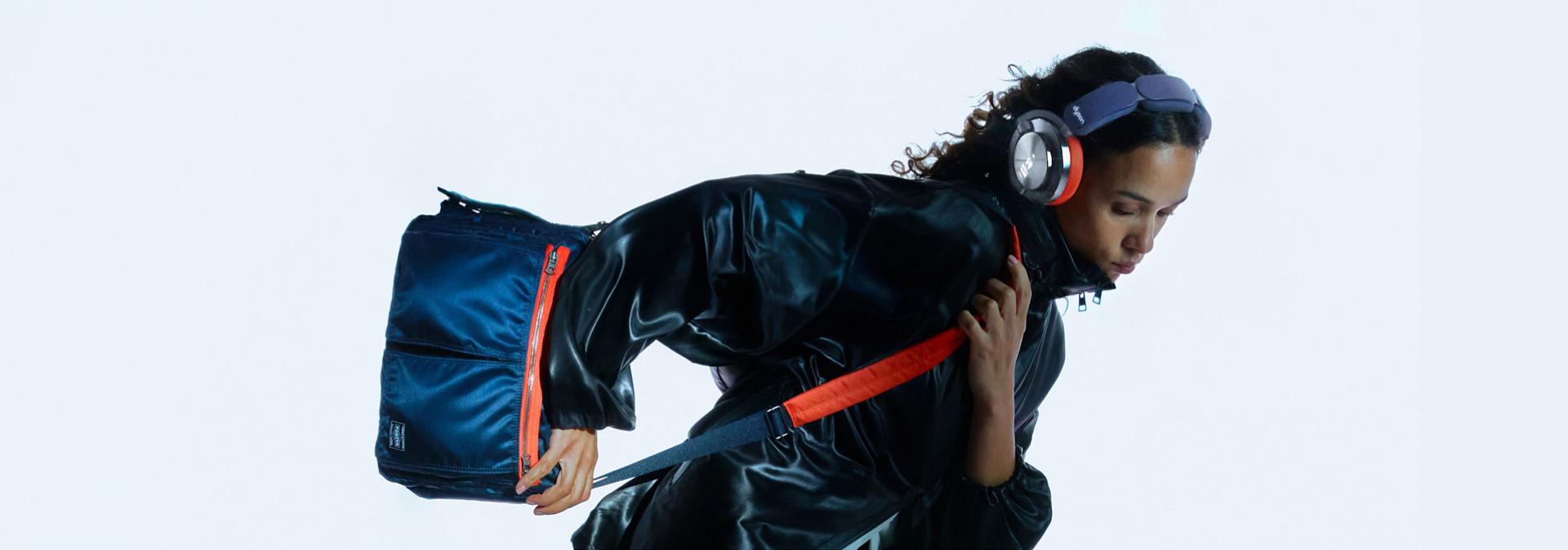 Model showcases Dyson OnTrac and PORTER custom shoulder bag in an active position.