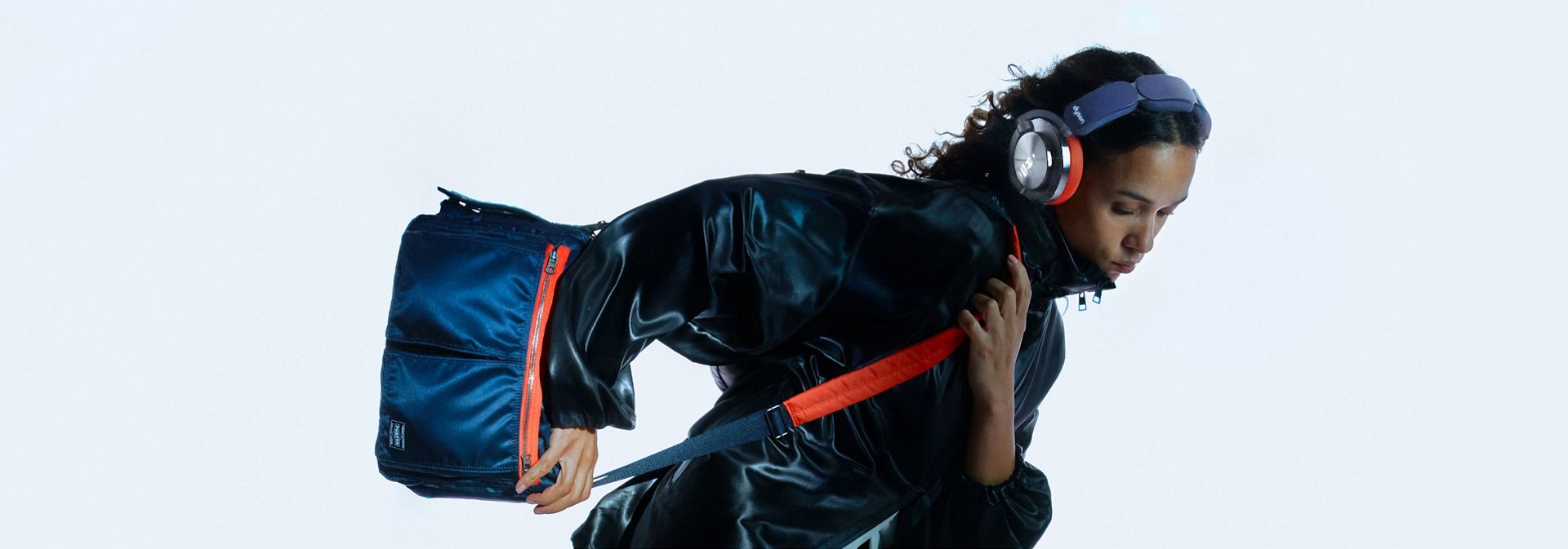 Model showcases Dyson OnTrac and PORTER custom shoulder bag in an active position.