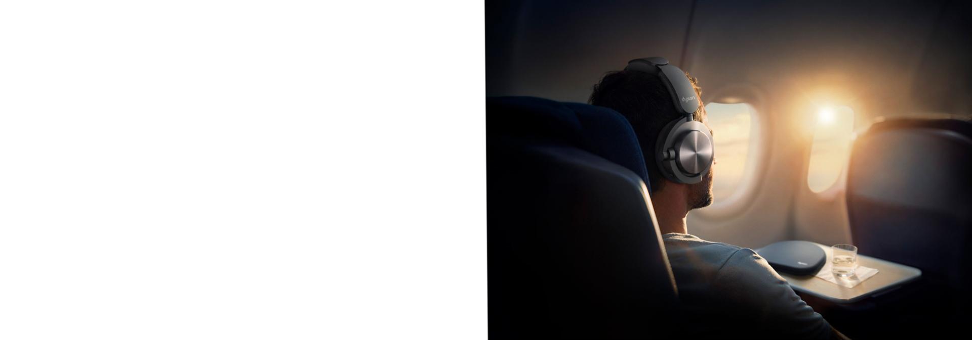 A person relaxing on a plane with OnTrac headphones.