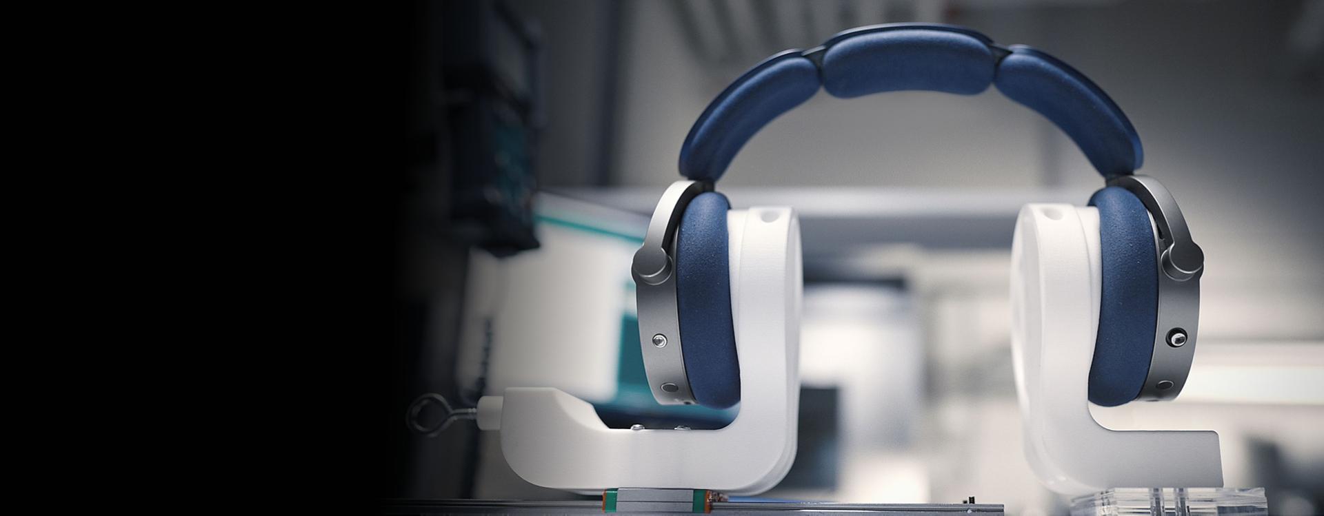 Dyson OnTrac headphones resting on custom stands in a laboratory.