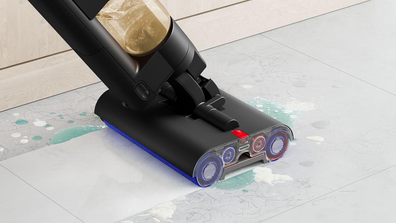 A close-up of the Dyson WashG1 wet cleaner tackling muddy pawprints on a hard floor The Dyson WashG1 wet cleaner tackling spills on a hard floor