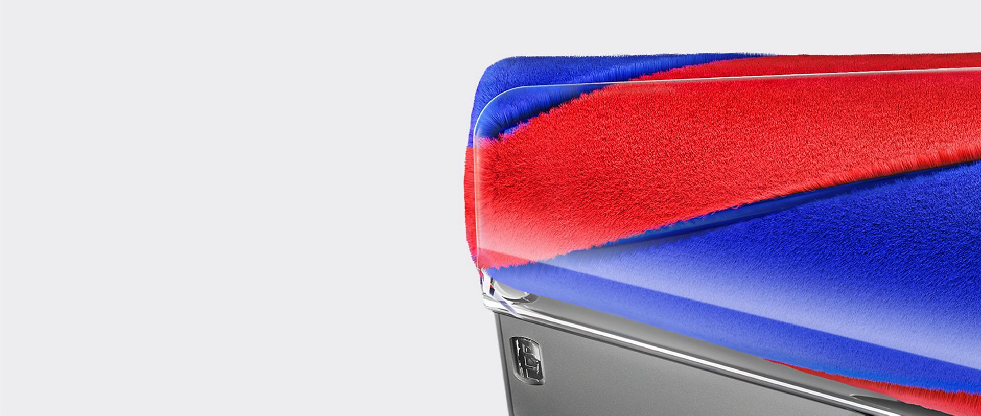 Close-up corner view of the red and blue conical brush bar of a Dyson Fluffycones cleaner head.