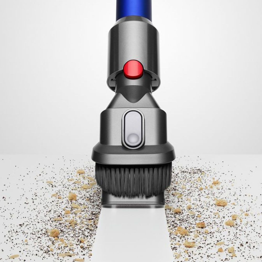 A Dyson combination tool cleaning dirt and debris from the floor.