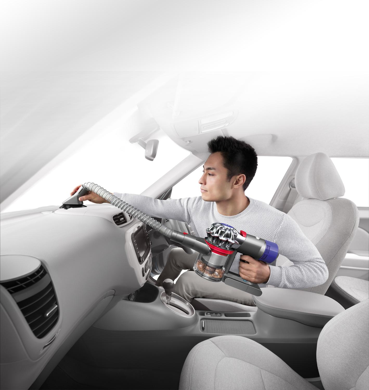着脱式延長ホースで車内を掃除している男性