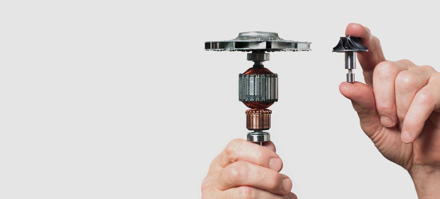 Person holding the old and new Dyson digital motors.