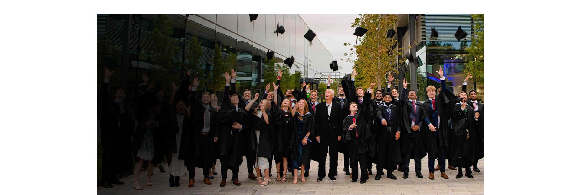 Dyson graduates throwing their mortar boards in the air.