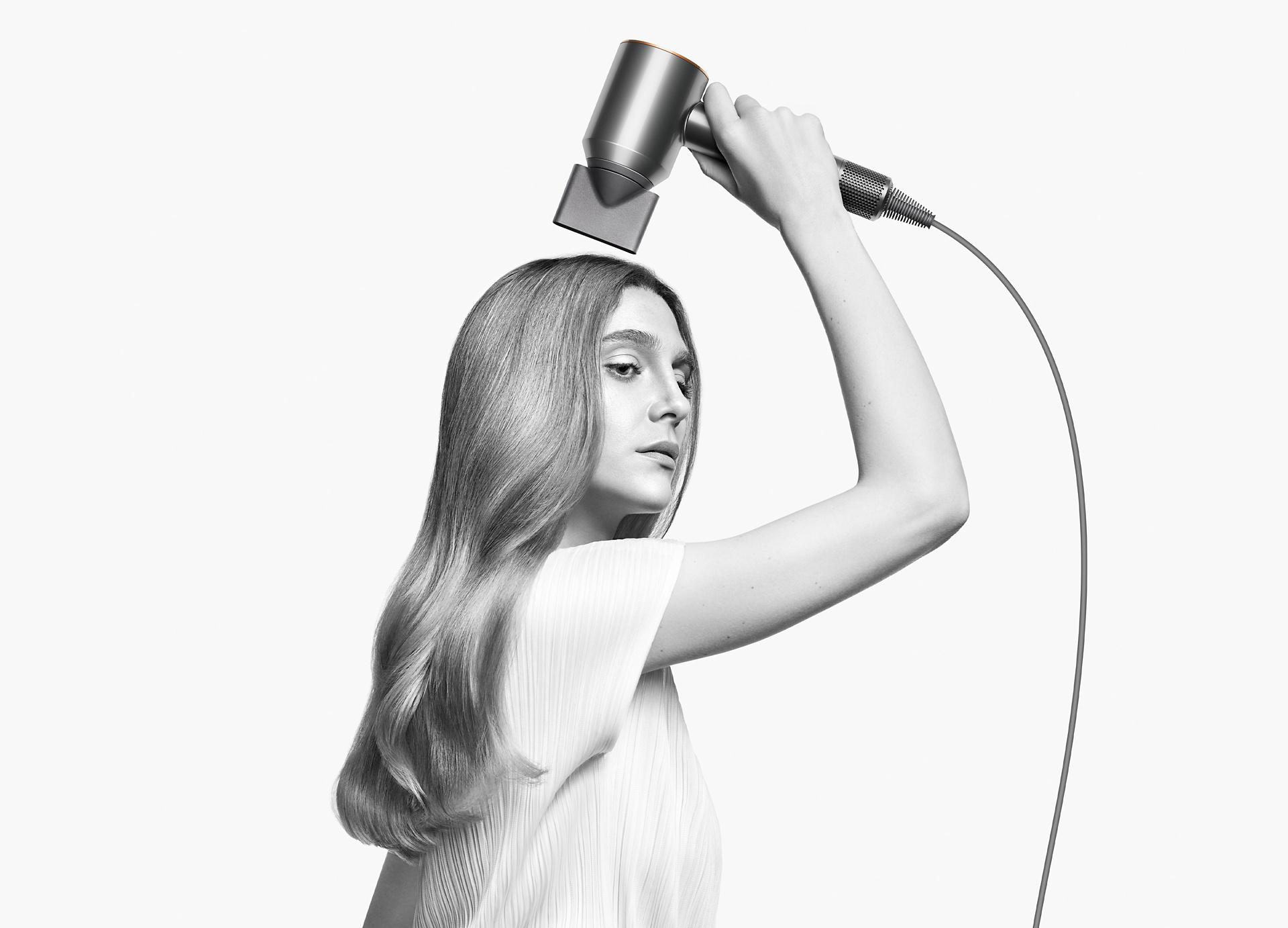 Kobieta używająca suszarki do włosów Dyson Supersonic