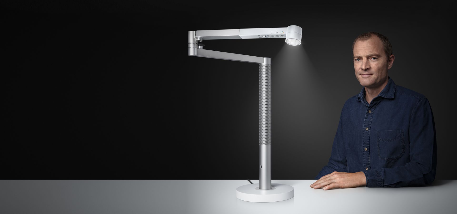Jake Dyson sitting next to the Dyson Solarcycle™ task light