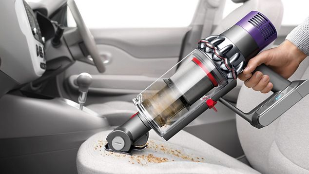 Dyson Cyclone V10 vacuum cleaner being used a handheld to clean car interior