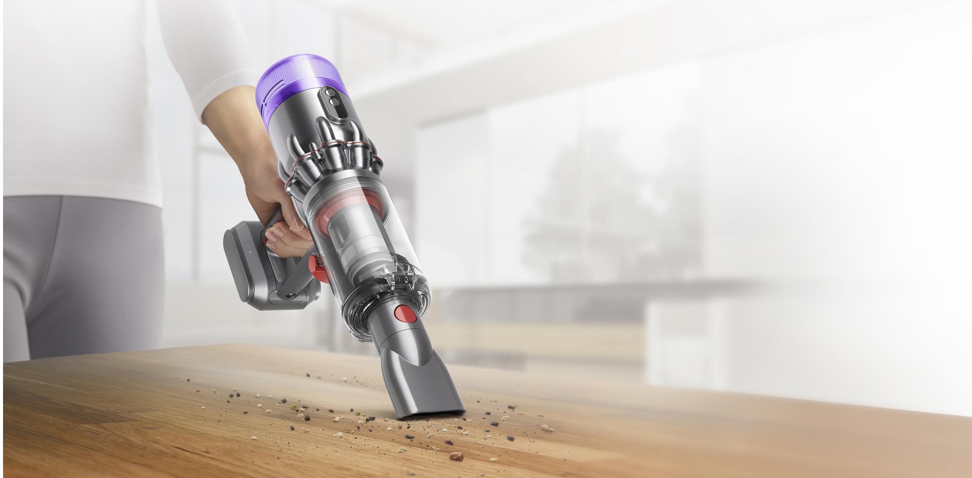مكنسة Dyson Humdinger بينما تُنظّف مخلفات طاولة