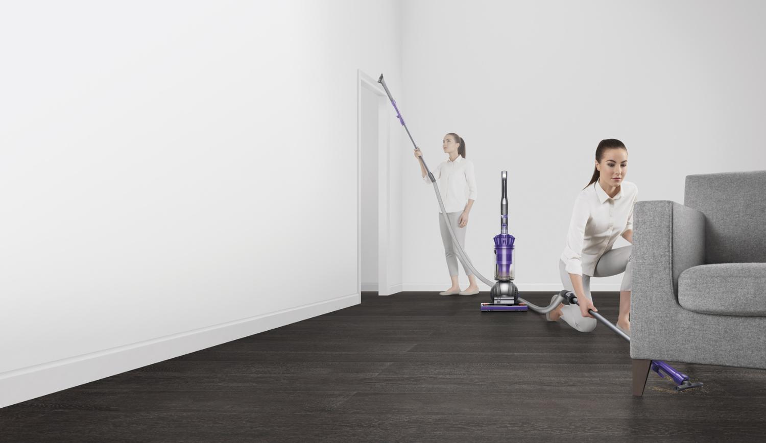 Femme utilisant un aspirateur Dyson V11 à main pour nettoyer un mur