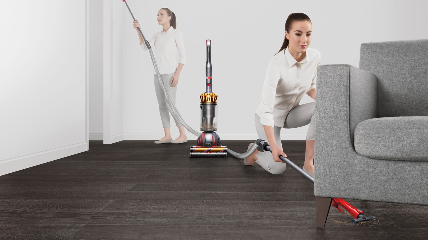 Woman cleaning under a couch and the ceiling with the Dyson Ball Animal 3 Complete vacuum