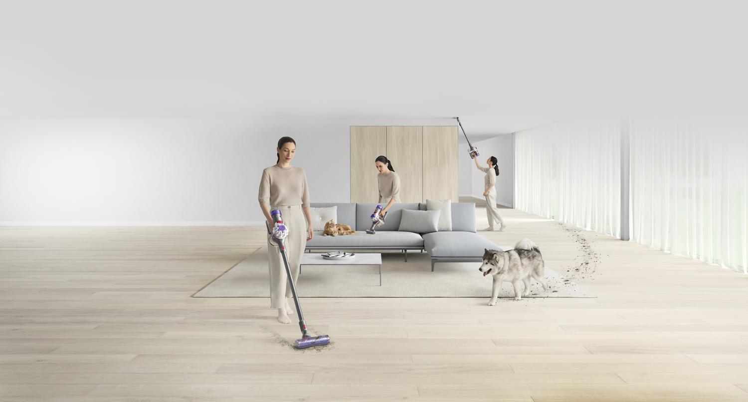 Woman cleaning living room with dog tracking in dirt