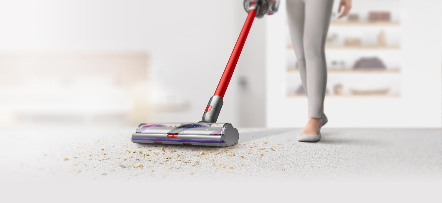 Cordless vacuum cleaning up debris from floor