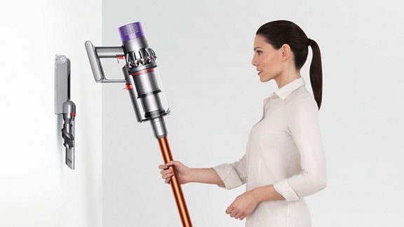 Dyson V10 Absolute cordless vacuum being placed into charging dock.