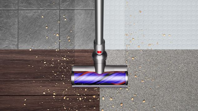 Dyson V10 vacuum de-tangling Motorbar™ cleaning debris from flooring