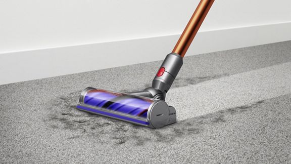 Dyson V10 Absolute cordless vacuum cleaner picking up debris from carpet.