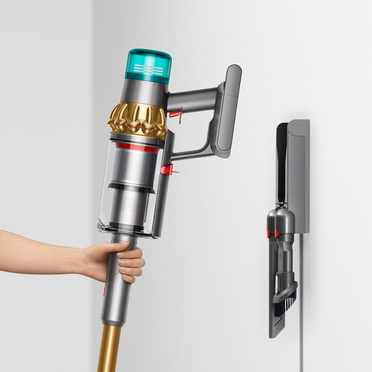 Пользователь устанавливает пылесос для влажной и сухой уборки Dyson V15s Detect Submarine на настенную док-станцию. Dyson V15s обнаруживает подводный пылесос для сухой и влажной уборки, установленный на настенной док-станции.