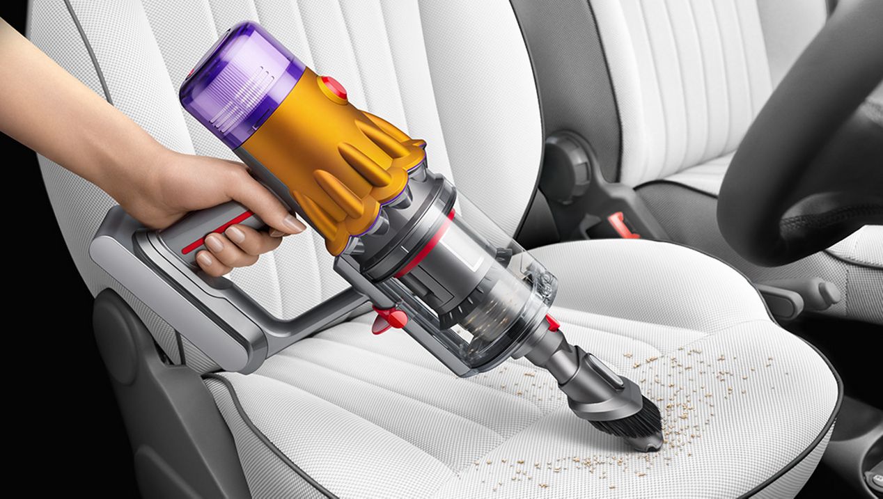 Dyson V12 in handheld mode cleaning a car seat