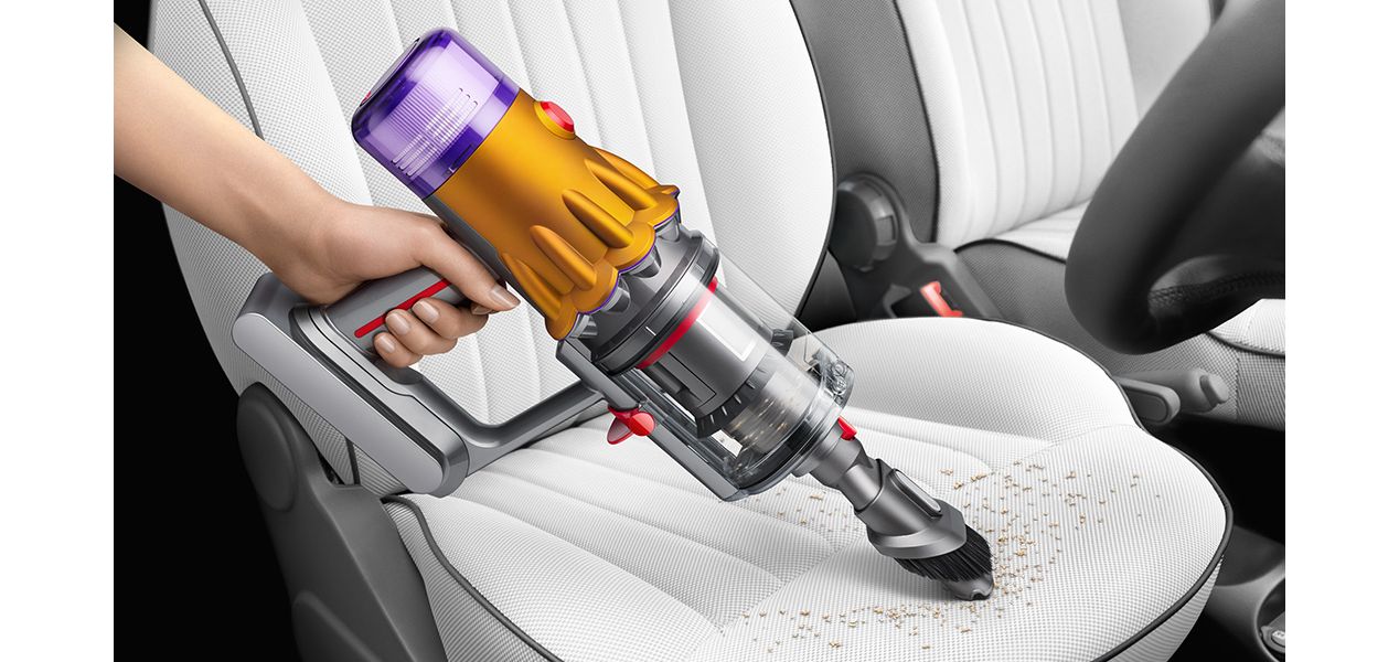 Dyson V12 in handheld mode cleaning a car seat